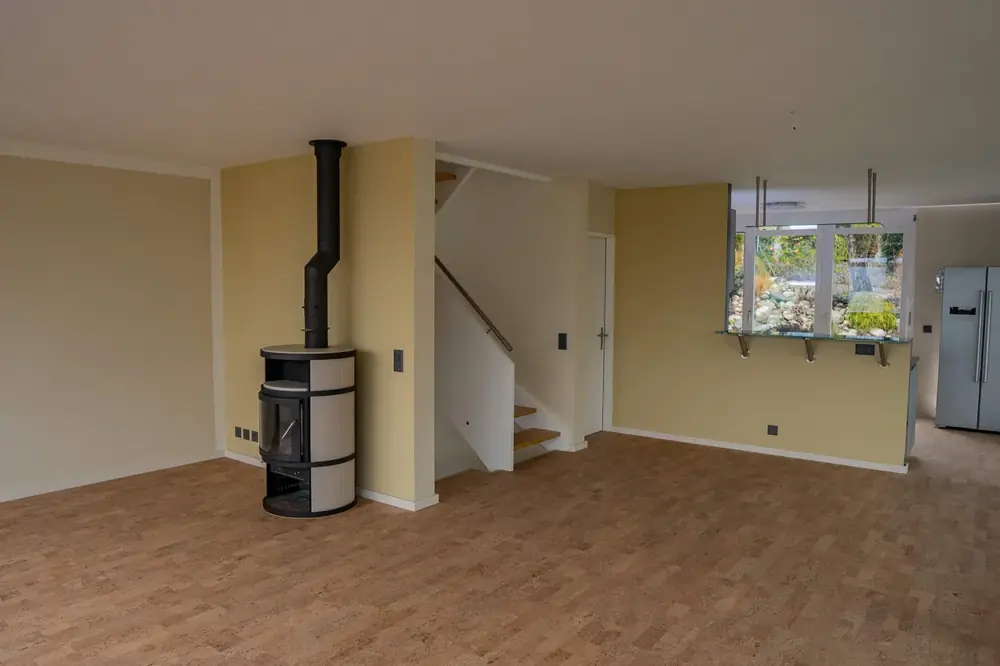 Renovierter Wohnraum mit neu gestrichenen Wänden und Treppenaufgang – Kreativ Maler